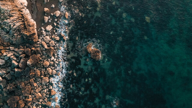 Aerial shot of a rocky shore at sunset along the Welsh coast