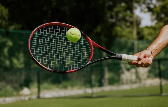 Tennis Action Scene Outdoors with Racket and Ball in Motion