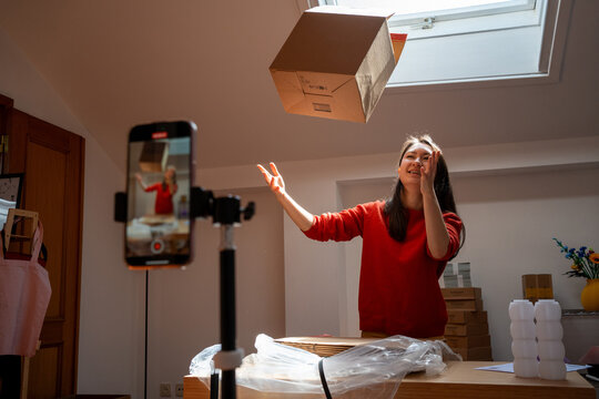 Woman tossing package during a creative filming session