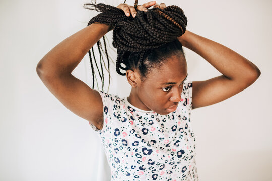  Overview of african american woman braiding her hair in a bun