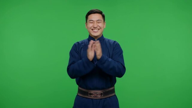 Cheerful Mongolian Man Clapping Hands in Traditional Deel Over Green Screen Background for Cultural Content and Celebration Concepts