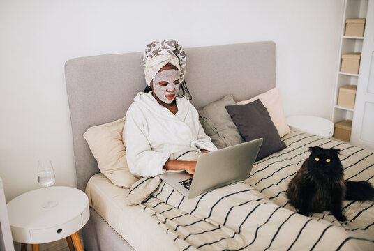 Photo of african american woman with beauty mask working from home