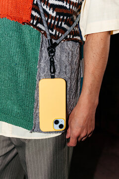 Model showcases phone accessory during fashion show in urban location