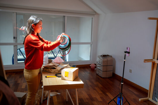 Woman Organizing Wires in a Room During the Afternoon