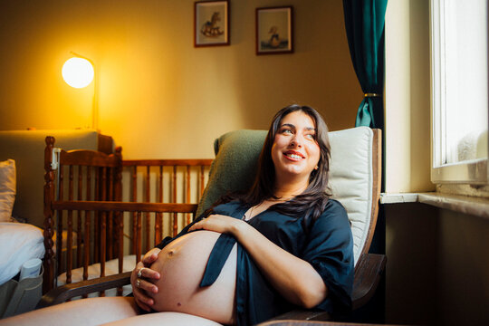 Smiling Pregnant Woman in Cozy Room