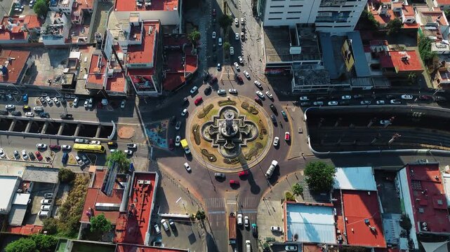Puebla Fuente de los Frailes Roundabout on Juarez Avenue with Active Vehicle Traffic Flow at Sunrise Vertical Tilt Movement Aerial Drone POV 4K 29fps Editorial Video Asset