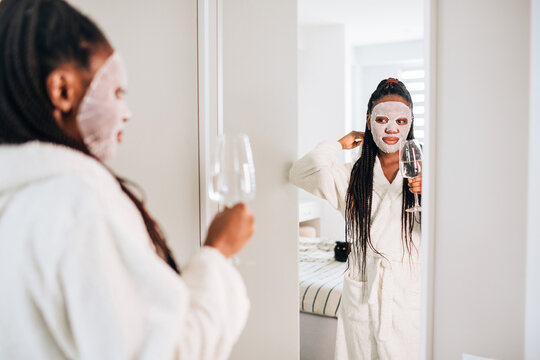 At home portrait of happy african american woman with facial mask 