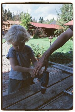 A man and his son are repairing a birdhouse.