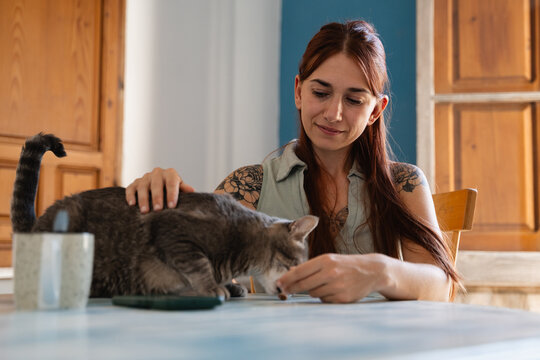  A woman giving her cat a treat