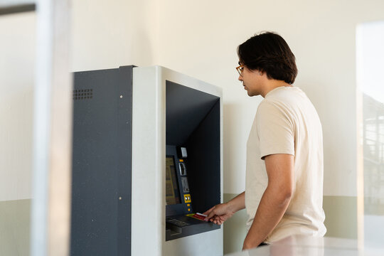 Young man charging train card at station. Bank, ATM, Money