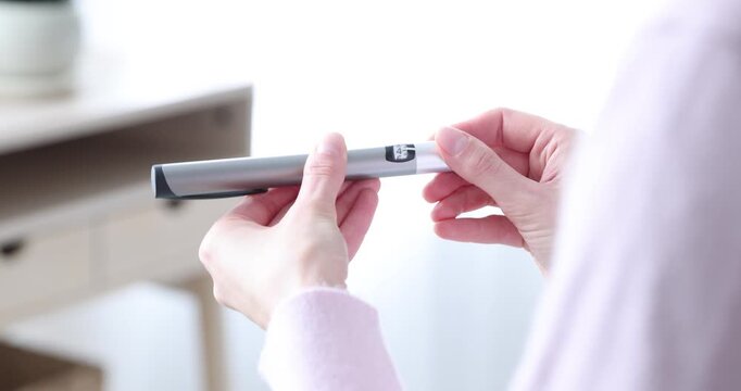 Diabetes. Woman with autoinjector at home, closeup
