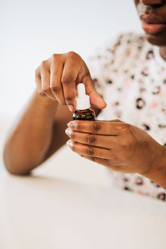 Photo of anonymous african american woman opening the beauty product 