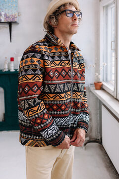 Man standing indoors wearing patterned jacket