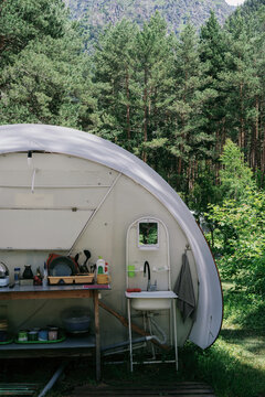 Camping setup in forest with glamping unit and sunny weather