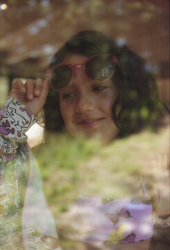 Girl with sunglasses behind the window