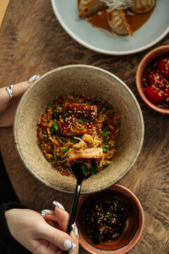 Spoonful of fried rice with pork and vegetables in ceramic bowl