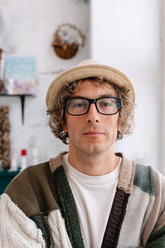 A man with curly hair and glasses