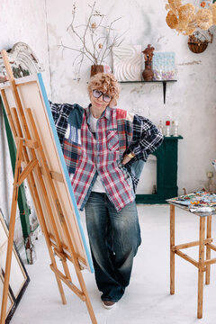 Artist in studio working on painting while wearing casual clothes