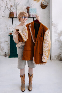 Woman holding a stylish jacket in a bright art-studio