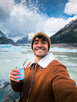 Man enjoying mate tea with a scenic mountain backdrop in Patagonia