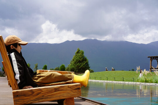 Chinese boy sits on a lounge chair 
