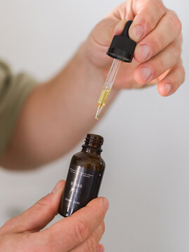 Man Applying Beard Oil From a Dropper in a Grooming Routine