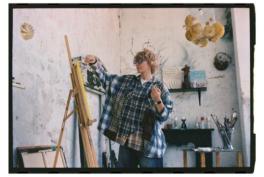 Artist creates colorful work in studio using paint and brushes