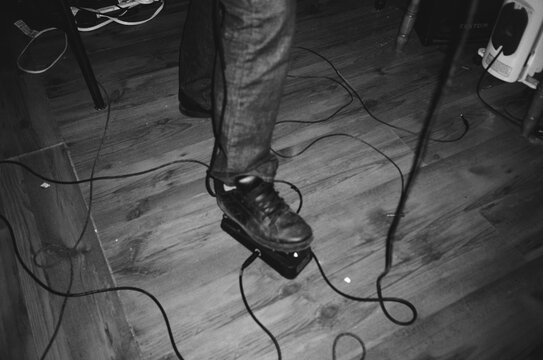 Close Up of Guitarist Foot Pressing Effects Pedal on Floor