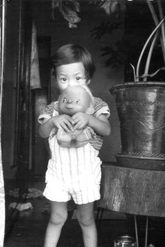 Child Holding a Doll Indoors
