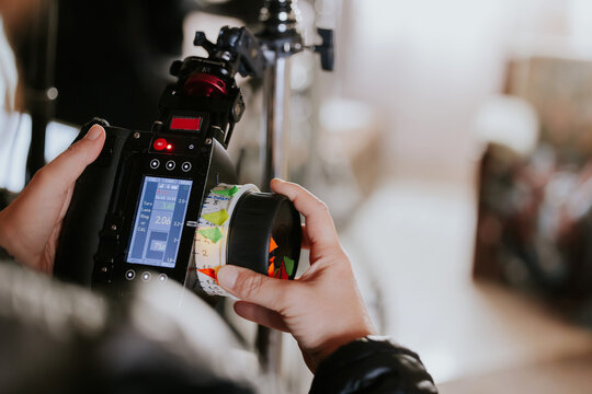 Cameraman adjusting professional video equipment settings