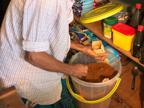 Spice Shop owner measuring out a scoop of curry powder 