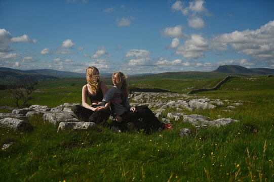  2 sisters sitting taking photos in the English Countryside