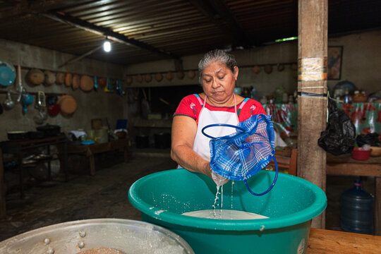 Woman preparing food using traditional methods indoors