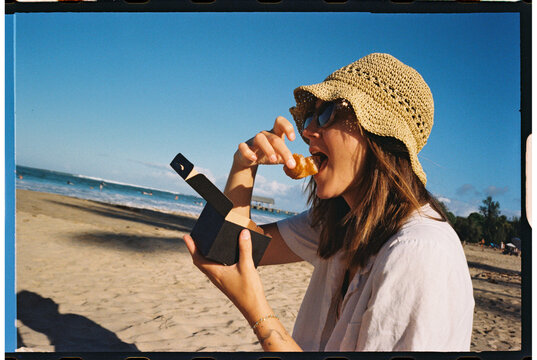 tourist eating donut at beach 