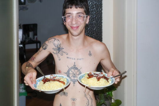 A boy Holds Two Plates of Food in a Home 