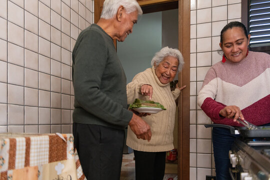 Three generations of family preparing traditional Indonesian food