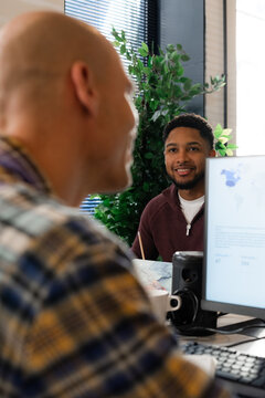 Smiling men talk in office
