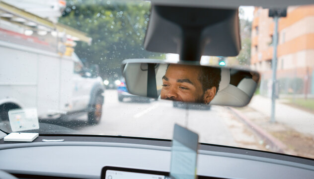Driver in car with city view
