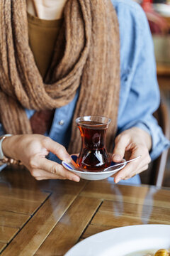 Person holding a glass of Turkish tea