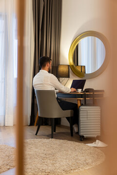 Businessman Working on Laptop in Hotel Room