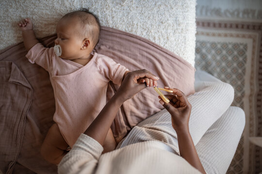Baby Sleeping While Mom Clips Nails in a Cozy Setting