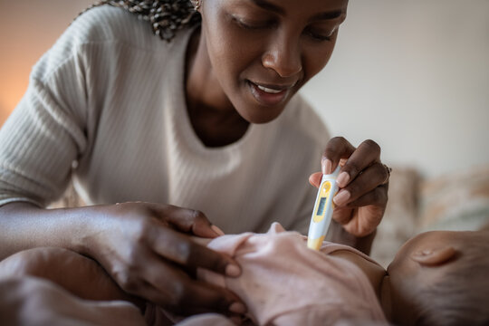 Mother Checks Baby's Temperature During Health Care Routine