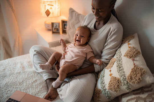 Baby enjoying time with mom in bedroom 