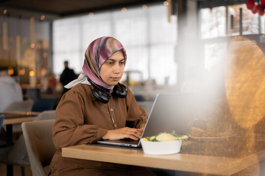 Woman in Hijab Working Remotely at a Coffee Shop