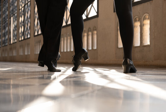 Cropped partners in shoes dancing together