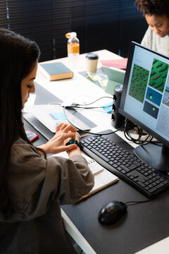 Woman using smartwatch while working at office space 