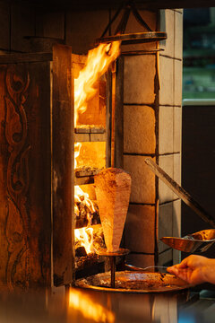 Meat Rotating on Vertical Grill Over Flame