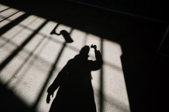 Person casting long shadow on grid pattern