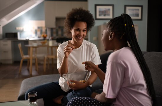 Content black girlfriends sharing secrets while spending time at home