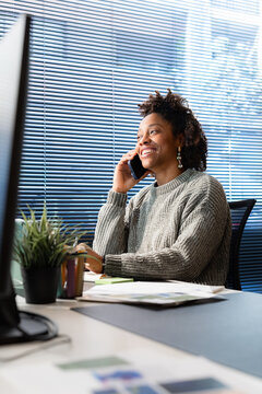Woman Talking on the Phone While Working at an Office Desk
